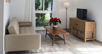 Wohnraum mit Couch und SAT-TV