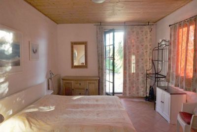 Schlafzimmer mit Terrassentür und Doppelbett