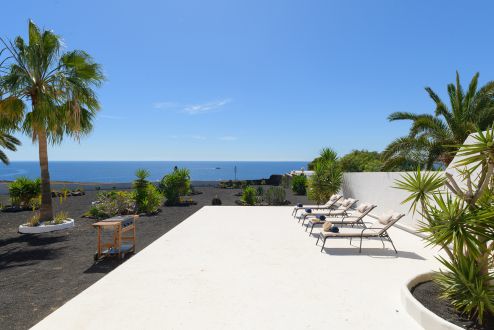Großzügige Villa Lanzarote, Puerto Calero. Garten und Sonnenliegen mit Blick zum Atlantik