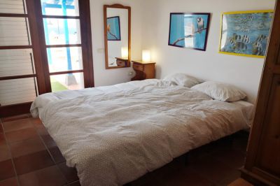 Schlafzimmer mit Doppelbett und Fensterfront